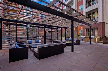 a patio with lounge furniture and a large building in the background